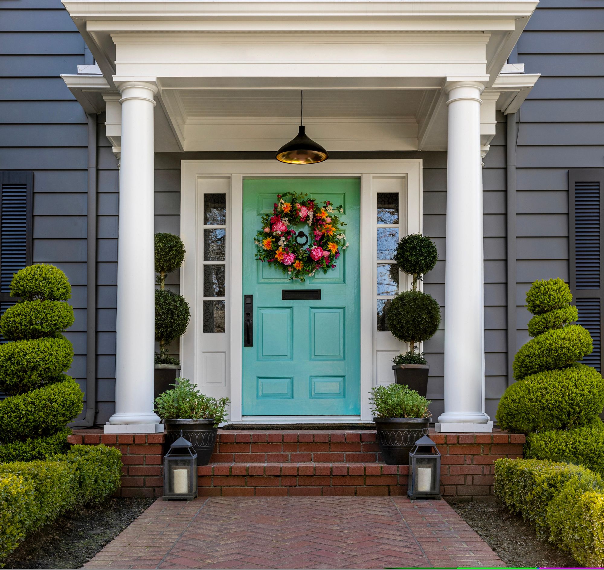 Teal entry door decorated with flower wreath