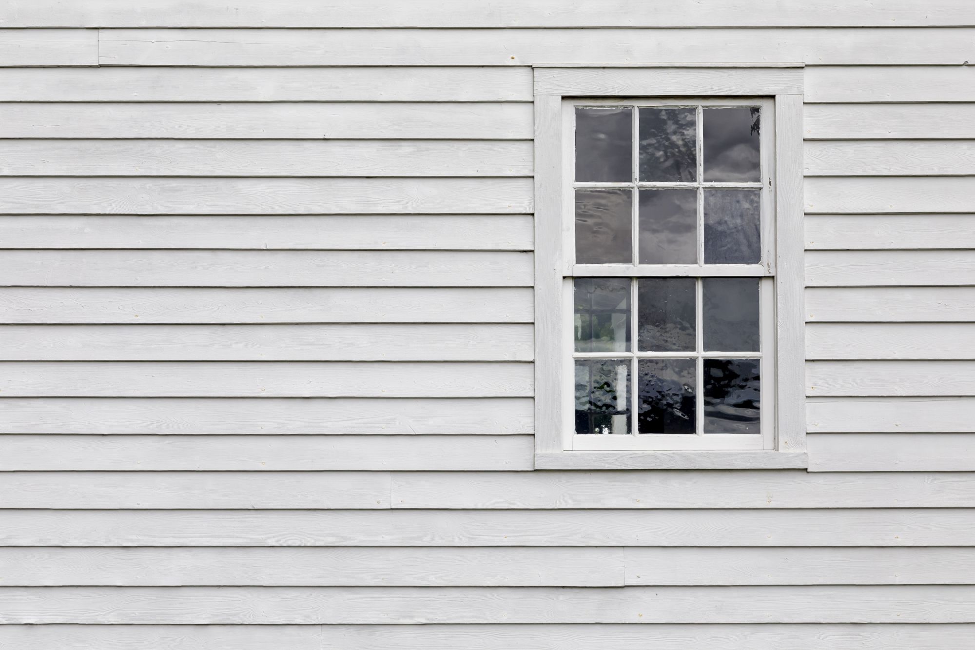 A suburban home with grey siding and a window