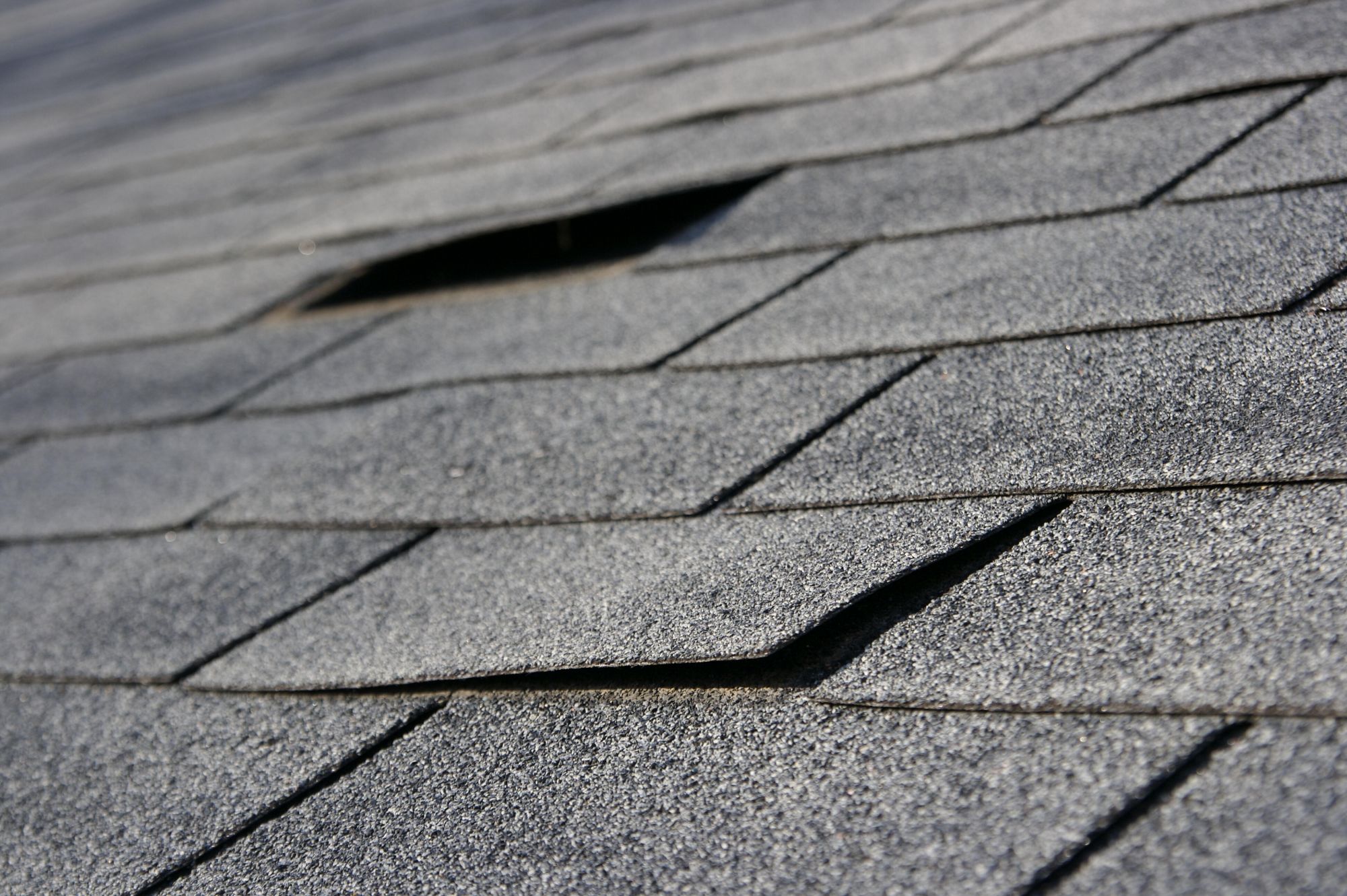 A roof with damaged shingles
