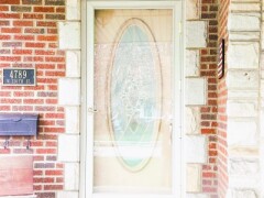 Storm door & cream-colored, glass detail front door installation by Fairview Home Improvement in Cleveland, Ohio area