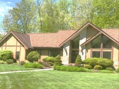 Stone & golden vertical siding installed by Fairview Home Improvement in Avon, Ohio